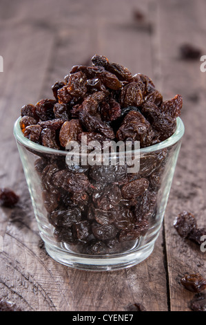 Glas gefüllt mit Rosinen auf hölzernen Hintergrund Stockfoto