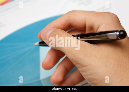 Die Hand mit dem Stift auf den Hintergrund des Diagramms. Stockfoto