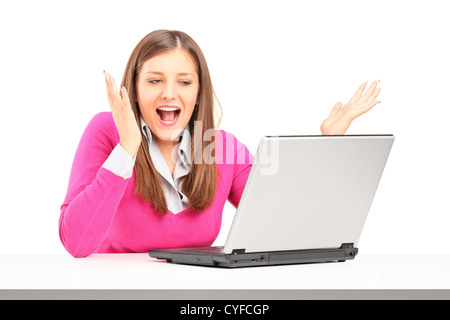 Begeistert junge Frau auf Laptop isoliert auf weißem Hintergrund Stockfoto