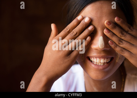 Schüchternes Myanmar Mädchen für ihre Augen mit Händen Stockfoto