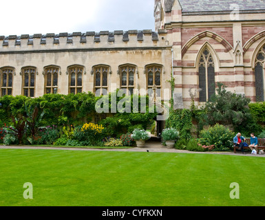 Zwei Menschen sitzen vor Viereck Gärten am Balliol College und Kapelle Oxford Oxfordshire England Europa Stockfoto