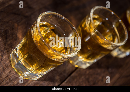 Rum-Aufnahmen in einer Linie auf hölzernen Hintergrund Stockfoto