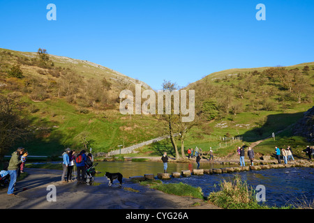 Menschen überqueren die berühmten Trittsteine auf dem Fluss Taube Dovedale Derbyshire UK Stockfoto