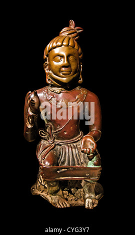 Antike indische Bronzeskulptur eines sitzenden asketischen oder vergöttlichten Königs, möglicherweise des Feuergottes Agni, aus Kaushambi, Uttar Pradesh, Indien. Stockfoto