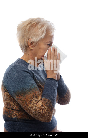 Reife Frau bläst ihre Nase mit Gewebe Stockfoto