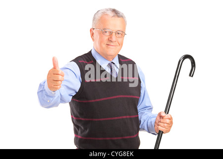 Ein senior Mann hält einen Stock und Daumen aufgeben isoliert auf weißem Hintergrund Stockfoto