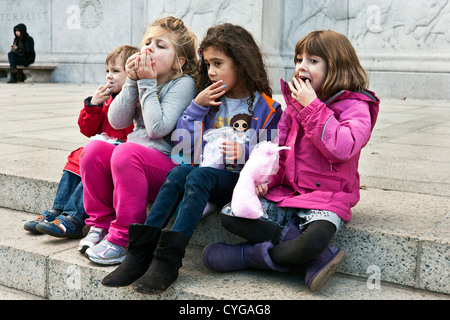 3 kleine Mädchen & kleiner Junge lecken Fingern unisono genießen Zuckerwatte auf Stufen des American Museum of Natural History Stockfoto