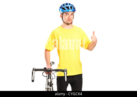 Eine lächelnde Radfahrer posiert neben einem Fahrrad und geben Daumen isoliert auf weißem Hintergrund Stockfoto