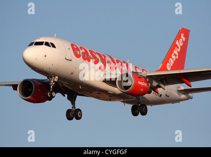 Günstige Flugreisen. Airbus A319 Passenger Jet plane, die Billigfluggesellschaft EasyJet auf Vorgehen gegen ein strahlend blauer Himmel. Nahaufnahme, Ansicht von vorne. Stockfoto