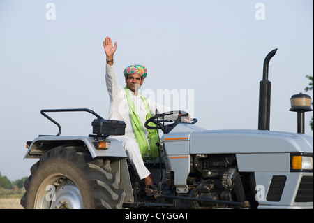 Landwirt einen Traktor zu fahren und seine Hand winken Stockfoto