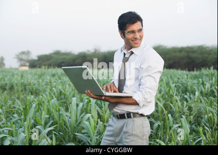 Geschäftsmann mit einem Laptop in einem Bauernhof Stockfoto