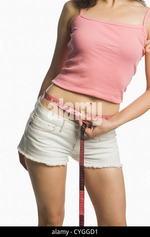 Frau, die ihre Taille mit einem Maßband messen Stockfoto