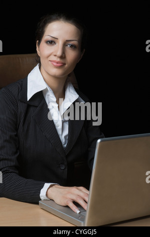 Porträt von eine Geschäftsfrau auf einem Laptop arbeiten Stockfoto
