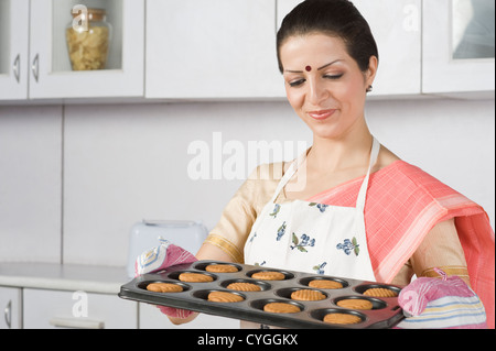 Frau mit einem Tablett mit Cookies in der Küche Stockfoto
