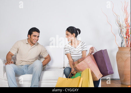 Paar sitzt auf einer Couch mit Einkaufstüten Stockfoto