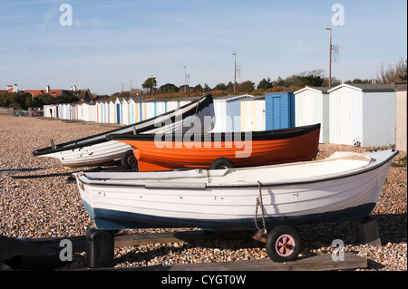 Kleine Küstenfischerei Boote am steinigen Strand von Serviceleistung Bognor Regis West Sussex England UK mit Reihe von Strandhütten geparkt Stockfoto