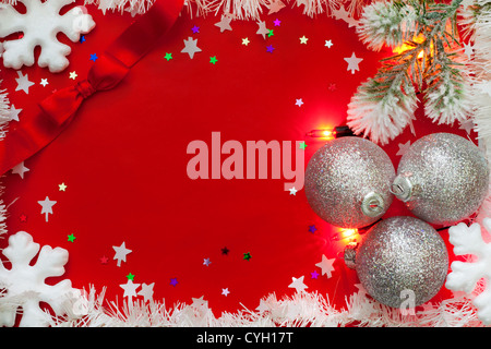 Christmas Lights Grenze mit Kugeln und Schnee auf rotem Grund Stockfoto