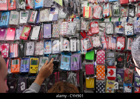 Kunden wählen Sie wählen Sie bunte Mobile Smartphone iPhone Fällen Stoßstangen Angebote in El Rastro Street Market Madrid, Spanien Espana Stockfoto