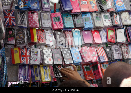 Kunden wählen Sie wählen Sie bunte Mobile Smartphone iPhone Fällen Stoßstangen Angebote in El Rastro Street Market Madrid, Spanien Espana Stockfoto