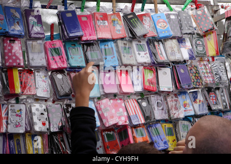 Kunden wählen Sie wählen Sie bunte Mobile Smartphone iPhone Fällen Stoßstangen Angebote in El Rastro Street Market Madrid, Spanien Espana Stockfoto