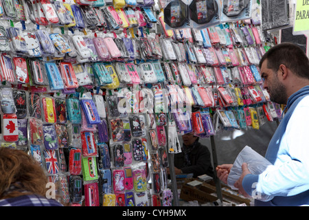 Kunden wählen Sie wählen Sie bunte Mobile Smartphone iPhone Fällen Stoßstangen Angebote in El Rastro Street Market Madrid, Spanien Espana Stockfoto