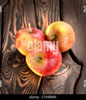 Rote Äpfel auf einem hölzernen Hintergrund Stockfoto
