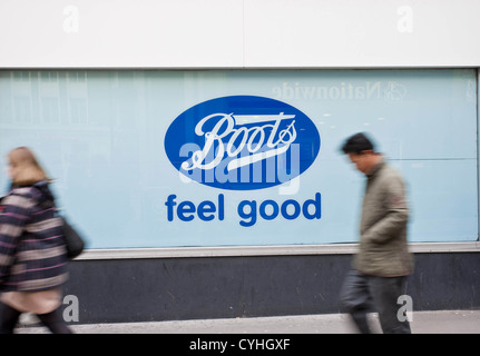 London, UK. 11.05.2012. (Im Bild) Menschen zu Fuß passieren einen Stiefel Fenster Schild. Peter Barbe / Alamy Stockfoto