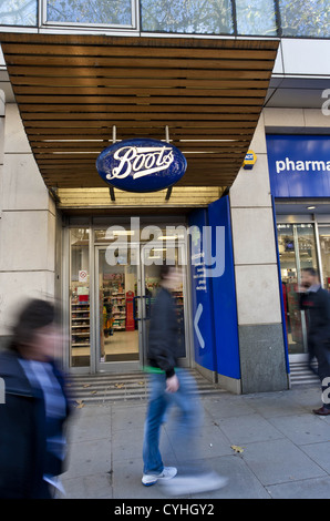 London, UK. 11.05.2012. (Im Bild) Menschen zu Fuß passieren einen Stiefel Shop Eingang in London. Peter Barbe / Alamy Stockfoto