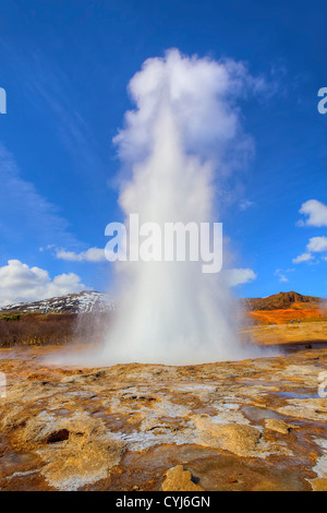 Isländische Geysir bricht mit blauen Himmel im Hintergrund Stockfoto