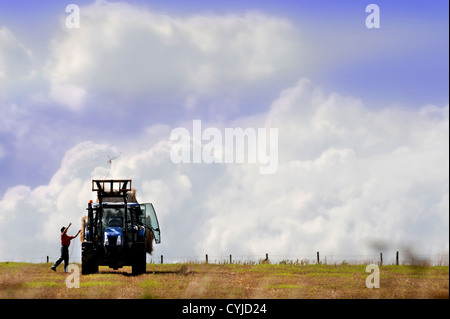 Ein Bauer wirft ein Seil über seine Anhänger von Heuballen in Gloucestershire UK Stockfoto