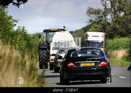 Verkehr stecken hinter einem Traktor auf einer Straße in Gloucestershire UK Stockfoto