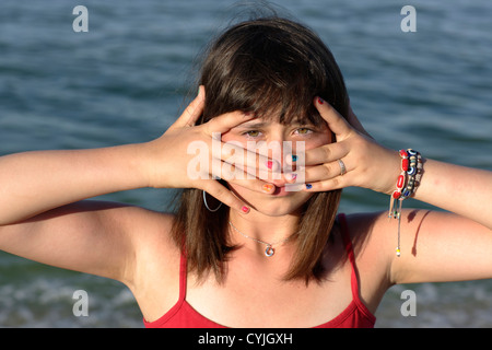 Mädchen zeigt ihre lackierten Nägel vor Gesicht Stockfoto