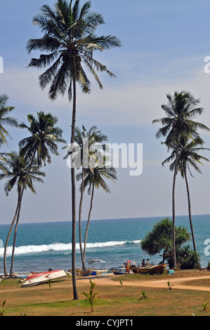 Einheimische mit ihren Fischerbooten am Strand im Amanwella Resort bei Tangalle im Süden Sri Lankas. Stockfoto