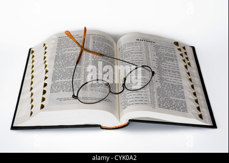 Eine aufgeschlagene Bibel mit einer Brille drauf liegen Stockfoto