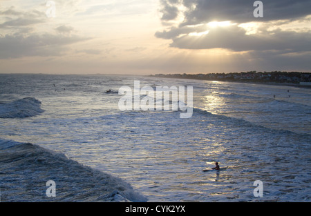 Surfen Folly Beach bei Sonnenuntergang als Hurrikan Sandy kommt In Stockfoto