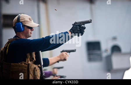 Eine Explosive Ordnance Entsorgung Techniker beteiligt sich an einer Kleinwaffen Qualifikation an Bord Flugzeugträger USS John C. Stennis (CVN-74). John C. Stennis ist in den USA bereitgestellt 5. Flotte Aufgabengebiet Durchführung von maritimen Sicherheits-Operationen, th Stockfoto