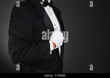 Closeup-Profil eines Mannes mit einem Tuxedo und weiße Handschuhe halten Revers. Stockfoto