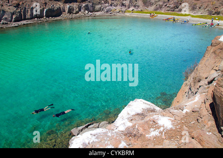 Mexiko, Baja, Sea of Cortez. Schnorcheln in Azure-farbigen Honeymoon Bucht auf Isla Danzante mit Kajaks am Strand. Stockfoto