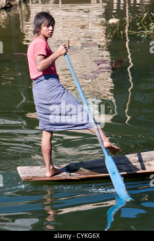 Myanmar, Burma. Junge burmesische Mann Rudern mit einem Bein in der gemeinsamen Stil zum Inle See, Shan-Staat. Stockfoto