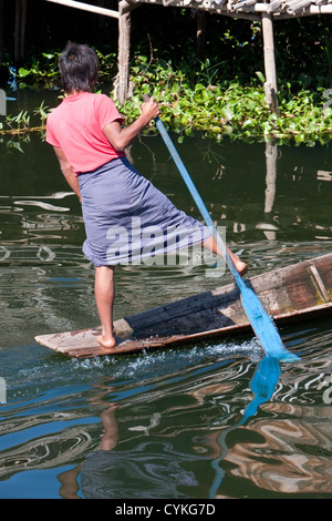 Myanmar, Burma. Junge burmesische Mann Rudern mit einem Bein in der gemeinsamen Stil zum Inle See, Shan-Staat. Stockfoto