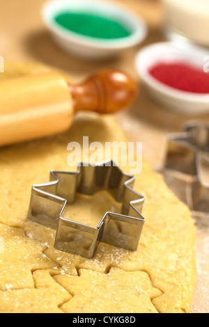 Weihnachtsplätzchen Backen: Ausstecher auf Zucker oder Butter Cookie-Teig mit Nudelholz und bunten Streuseln ausgerollt Stockfoto