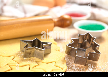 Weihnachtsplätzchen Backen: Ausstecher auf Zucker oder Butter Cookie-Teig mit Nudelholz und bunten Streuseln ausgerollt Stockfoto