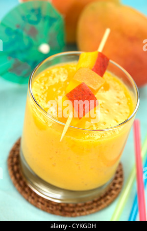 Frische hausgemachte Mango-Saft im Glas mit Mango Stücke auf Spieß oben auf das Getränk Stockfoto