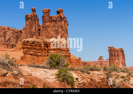 Three Gossips oder Three Sisters Rock Formation im frühen Morgenlicht im Arches National Park in Utah. Stockfoto