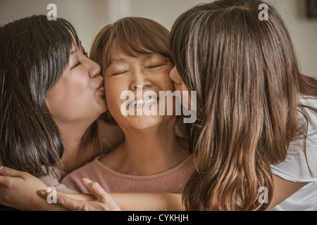 Mutter und Tochter küssen Großmutter Stockfoto