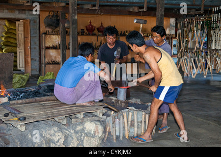 Myanmar, Burma. Drei junge Männer Hammer glühendes Metall gerade aus dem Schmied Feuer, Inle-See, Shan-Staat übernommen. Stockfoto