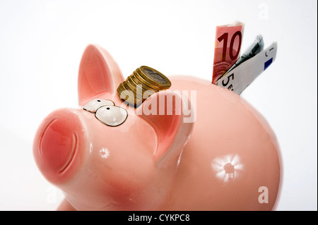 Eine rettende Schwein mit Euro-Münzen zwischen seinen Ohren Stockfoto