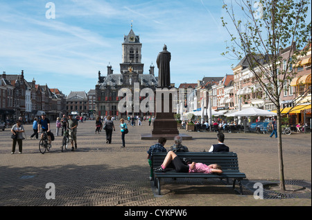Junge Frau auf der Bank schlafend blind in Delft Marktplatz (Markt Platz) Niederlande; Das Rathaus ist in der Ferne. Stockfoto