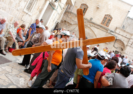 Mann trägt ein Kreuz auf dem Platz vor der Kirche des Heiligen Grabes in Jerusalem Stockfoto