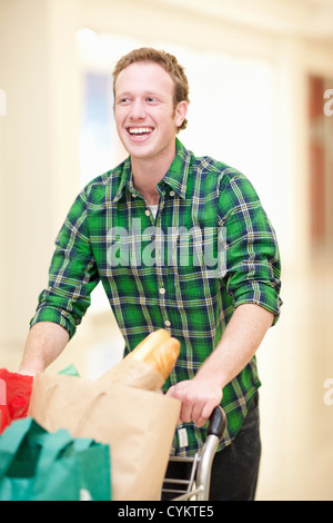 Mann schieben Einkaufswagen in der mall Stockfoto